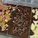 A hand adding various toppings to chocolate bars in a molding tray
